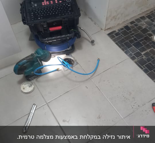 מחשב נייד על ארגז כלים, כבל כחול, כלי עבודה על הרצפה